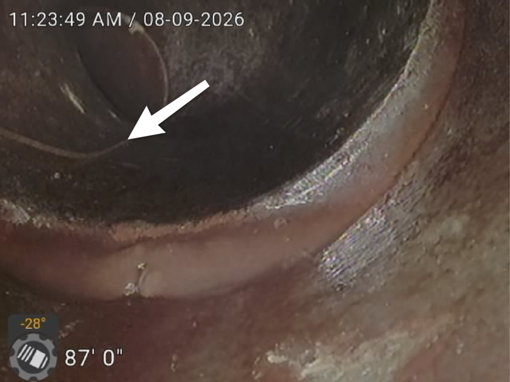 Sewer scope camera showing a cracked sewer line approximately 87 feet into the sewer lateral